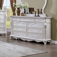 a white dresser and mirror in a room