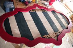 a large wooden sign sitting on top of a table covered in red and black stripes