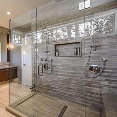 a large bathroom with a walk in shower next to a double sink vanity and mirror