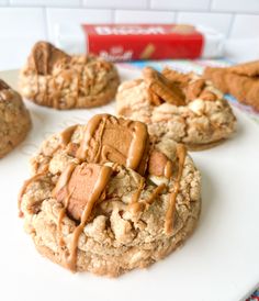 cookies with peanut butter and caramel drizzled on them sitting on a white plate