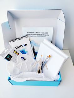 an open box with art supplies inside on a table