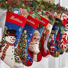 christmas stockings hanging from a mantel decorated with snowmen and santa clauss,