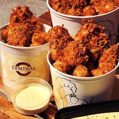 three buckets filled with fried food sitting on top of a table