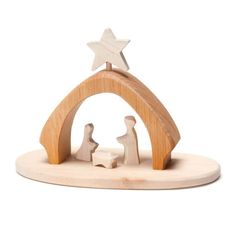 a wooden nativity figurine with a star above it on a white background