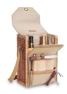 an open wicker picnic basket with wine bottles and utensils