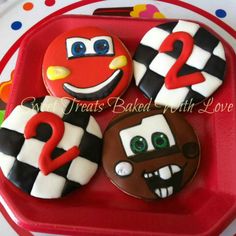 three decorated cookies in the shape of numbers on a red tray with polka dot dots