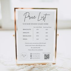 a price list sign sitting on top of a white tablecloth with gold trimming