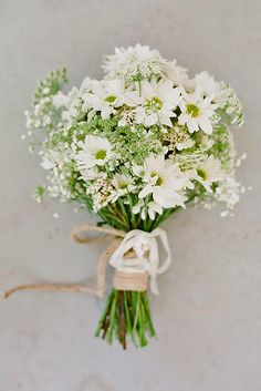 a bouquet of white flowers tied to a string