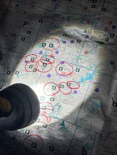 a close up of a map with red circles on it and a black object in the middle