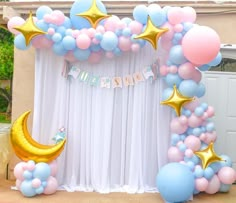 a balloon arch decorated with stars and moon balloons