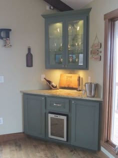 a kitchen with gray cabinets and wooden floors