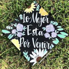 a black graduation cap with flowers on it that says,'la mejo esta por ver '