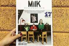 a person holding up a magazine about milk decoration