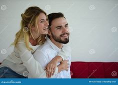 a man and woman hugging on the couch