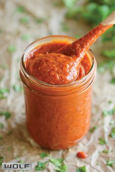 homemade enchilade sauce in a jar with a wooden spoon