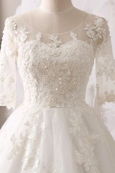 a white wedding dress with sleeves and flowers on it