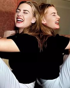 two women are laughing and posing for the camera