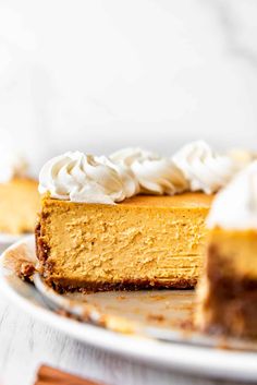 a slice of pumpkin cheesecake on a plate with whipped cream around the crust and toppings