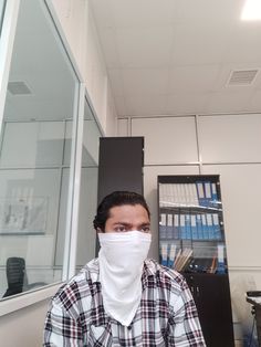 a man wearing a face mask in an office