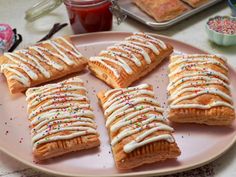 several pastries on a pink plate with sprinkles