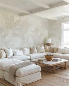 a living room filled with white furniture and pillows