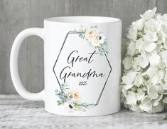 a white coffee mug with the words great grandma on it next to some hydranges