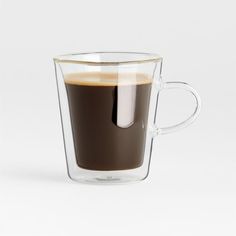 a glass cup filled with liquid on top of a white table