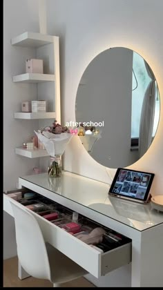 a white desk with a mirror on top of it and a tablet in front of it