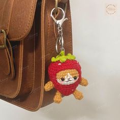 a crocheted keychain hanging from a brown purse