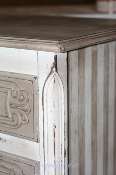 an old white chalk paint dresser with stripes on it