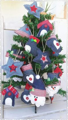 a small christmas tree decorated with blue and red fabric bears, stars and snowflakes