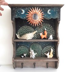 a shelf that has some animals on it and a sun in the sky above it