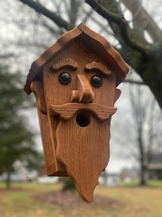 a wooden birdhouse with a man's face on it