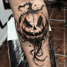 a black and white halloween pumpkin tattoo on the right arm with swirls around it