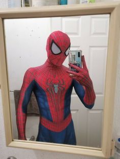 a spider man is taking a selfie in the mirror