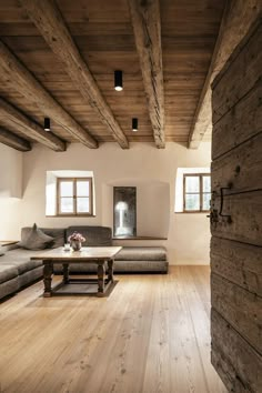 a living room with wood floors and exposed beams