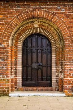 an old brick building with a wooden door