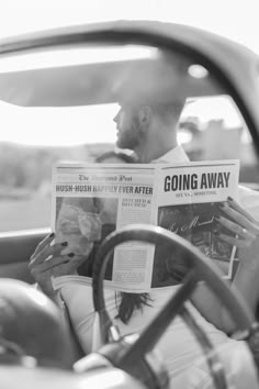 a man reading a newspaper while sitting in a car