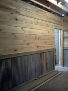 an empty room with wooden walls and windows