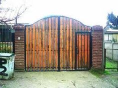 an iron gate with wooden panels and numbers on it