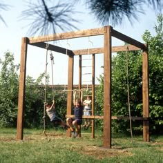 two children playing on a wooden swing set