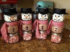 there are four snowmen made out of mason jars