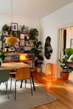 a dining room with wooden floors and plants on the wall