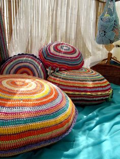 colorful crocheted round pillows on a bed