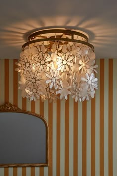 a chandelier hanging from the ceiling in a room with striped wall paper on the walls