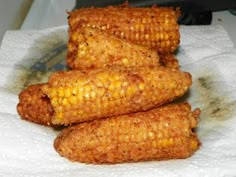 three corn on the cob sitting on top of a napkin