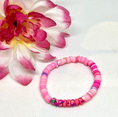 Add a pop of color and a touch of charm to your wrist with this handmade polymer clay beaded bracelet. This lovely piece features a perfect blend of pink and purple spacer beads, creating a delightful contrast that will add a playful and feminine flair to any outfit. Whether you're looking for a unique accessory for yourself or a thoughtful gift for a friend, this friendship bracelet is sure to bring joy and sweet style to your day. Made with care and attention to detail, each bead is uniquely crafted to ensure a one-of-a-kind piece that you'll love to wear on repeat. Playful Pink Beaded Bracelets, Pink Hand-strung Heishi Beads Friendship Bracelets, Pink Heishi Beads Friendship Bracelets For Beach, Colorful Beaded Polymer Clay Friendship Bracelets, Playful Pink Bracelets With Round Beads, Playful Pink Heishi Beaded Bracelets, Trendy Pink Heishi Beads Friendship Bracelet, Pink Stretch Bracelet With Spacer Beads As Gift, Pink Hand-strung Stretch Bracelet For Beach