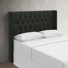 a black headboard with white pillows in a bedroom