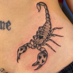 a scorpion tattoo on the back of a woman's stomach