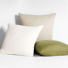 two pillows sitting next to each other on a white surface